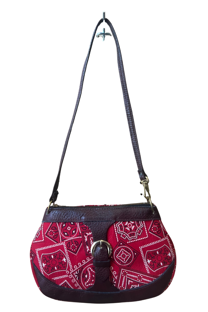 A small shoulder bag with a red and white paisley bandana pattern on the front, dark brown faux-leather trim, and a dark brown shoulder strap, shown against a plain white background.